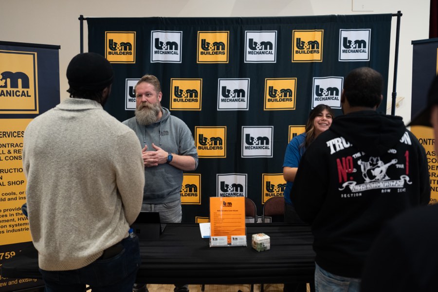 A trades employer talking with candidates at their table
