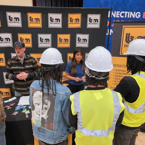 Students in hard hats at the B&M Builders table